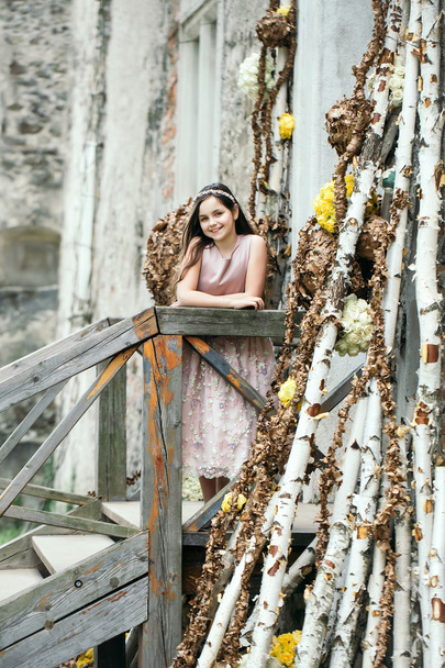 Çiçek dekorasyonu ile merdivenlerde gülümseyen kız - Fotoğraf, Görsel