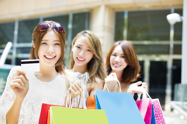 heureux jeunes femmes montrant sacs à provisions et carte de crédit
 - Photo, image