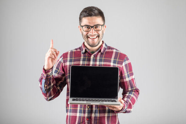 Man with laptop showing attention gesture - Fotoğraf, Görsel