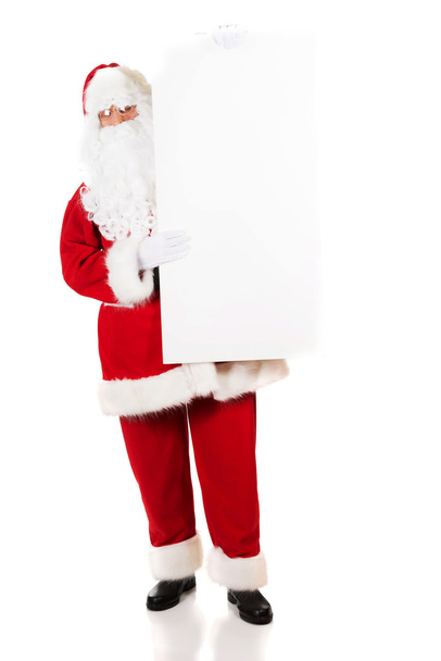 Санта-Клаус держит белый чистый знак
 - Фото, изображение