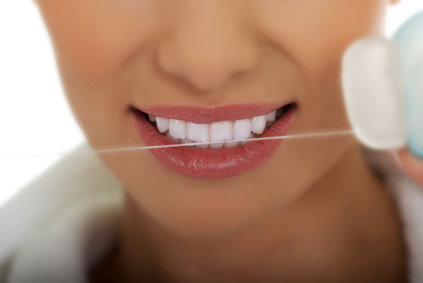 Kobieta używająca nici dentystycznej. - Zdjęcie, obraz