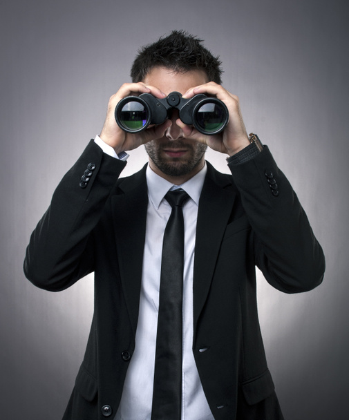 Businessman looking through binoculars - Photo, Image