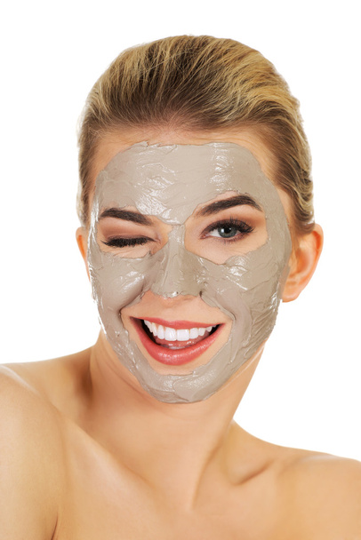 Young happy woman with facial mask. - Фото, изображение
