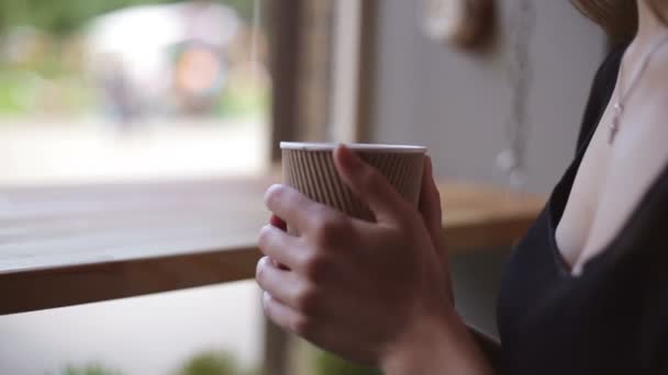 Woman drinking coffee in restaurant or cafe - Кадри, відео