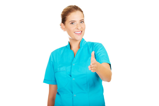 Smile female doctor or nurse giving hand for handshaking - Photo, Image