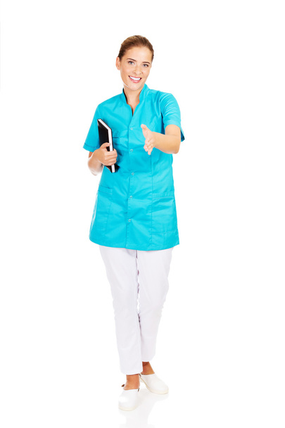 Young female doctor or nurse holding black notes - Fotó, kép