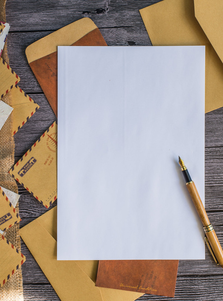 Carta com caneta e envelopes em uma mesa de madeira
 - Foto, Imagem