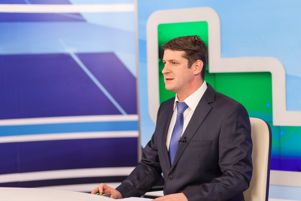 Male anchorman in tv studio. Live broadcasting - Photo, Image