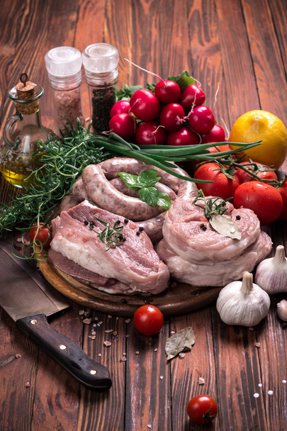 Açougueiro fresco cortou variedade de carne guarnecida com alecrim fresco na mesa de madeira
 - Foto, Imagem
