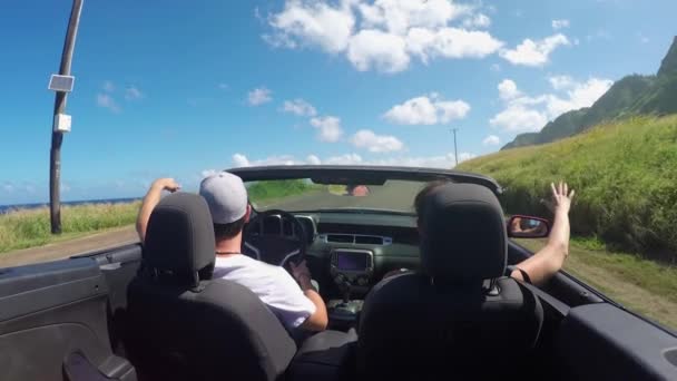 Zavřít: šťastný mladý pár, který jede po pobřežní silnici v červeném kabrioleu - Záběry, video