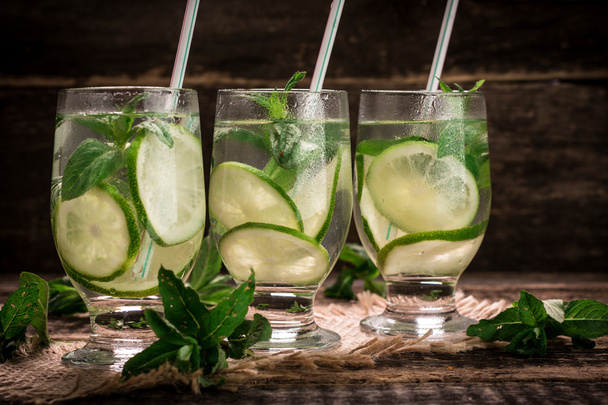 detox water with a lemon, lime and mint on a wooden table - Фото, зображення