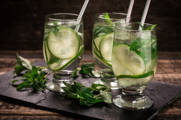 detox water with a lemon, lime and mint on a wooden table - Фото, зображення
