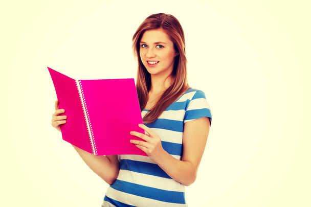 Smiling teenage woman reading her notes - Photo, image
