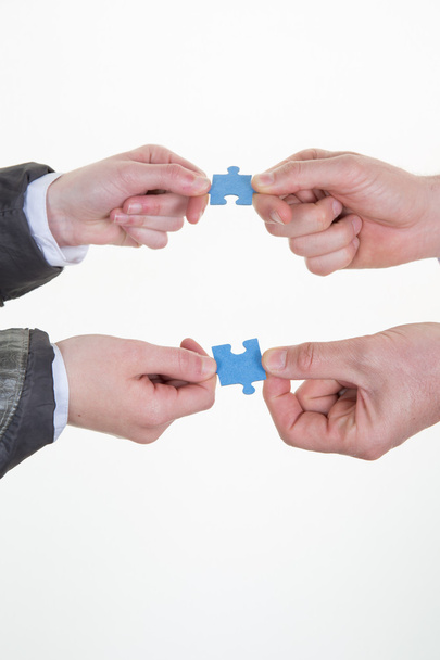 Hands of businesspeople holding puzzle pieces in office - Photo, Image
