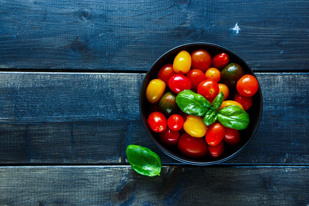 Tomatoes in black bowl - Photo, Image