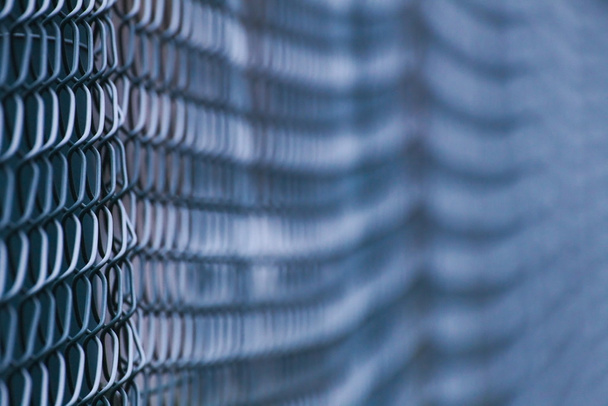 Abstract shot of a green wire mesh fence with defocusing effect - Photo, Image