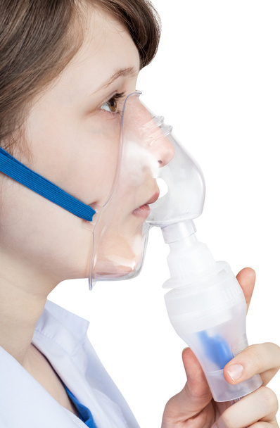meisje inhaleert met gezichtsmasker van moderne inhalator - Foto, afbeelding