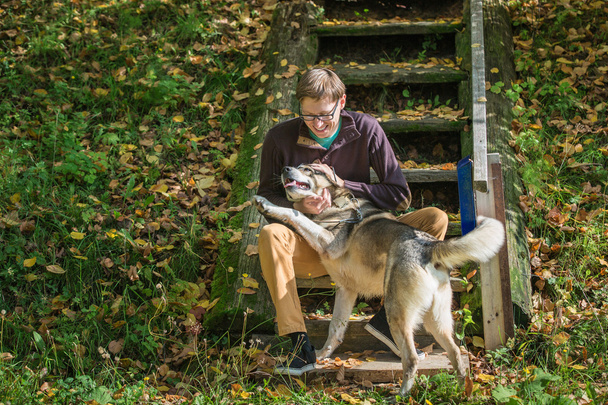 Man sitting on stairs with dog - Foto, Bild