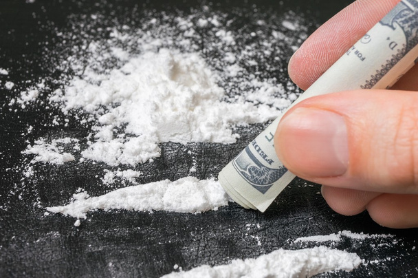 Junkie is snorting cocaine white powder with rolled banknote. Na - Photo, Image