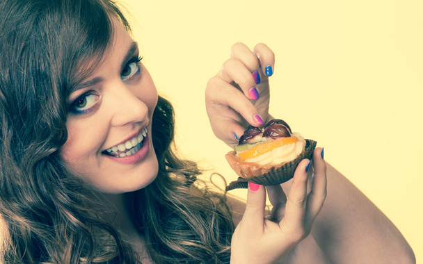 Closeup woman eating fruit cake sweet food - Photo, image