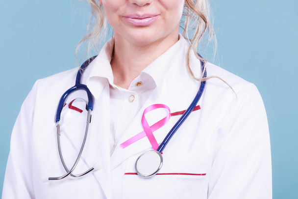 Pink ribbon with stethoscope on medical uniform. - Foto, immagini
