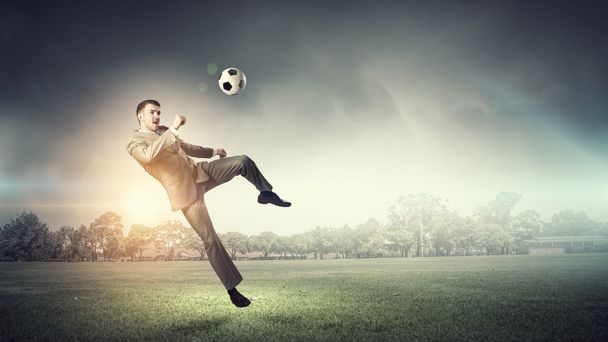 Businessman kicking ball - Photo, image