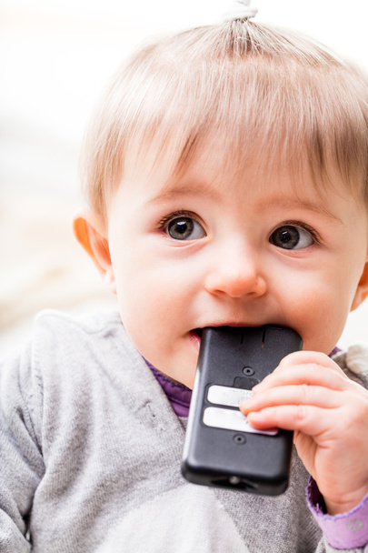 child tasting a remote control to check - Photo, Image