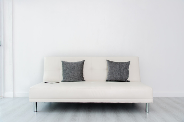 Δισκίο σε λευκό καναπέ κρεβάτι σε λευκό δωμάτιο και όροφο - Φωτογραφία, εικόνα