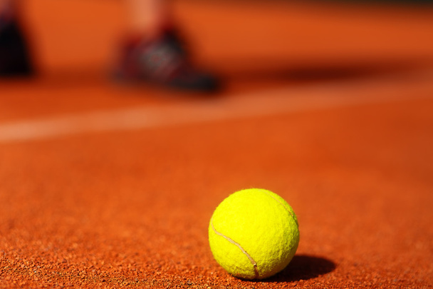 tennis court with tennis ball and man legs on background. - Fotó, kép