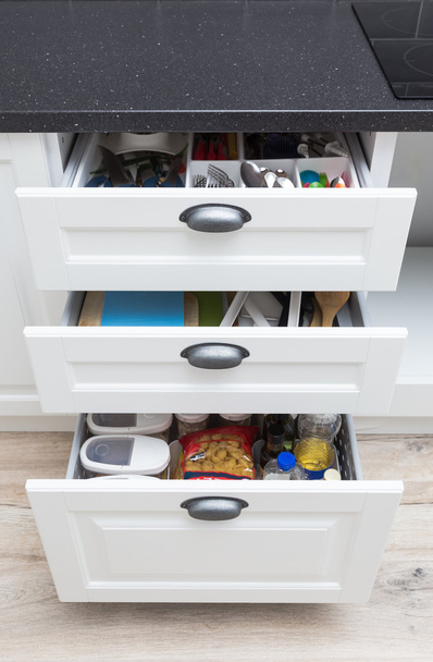 Küchenschrank mit geöffneten Schubladen mit Verschiedenes im Inneren - Foto, Bild