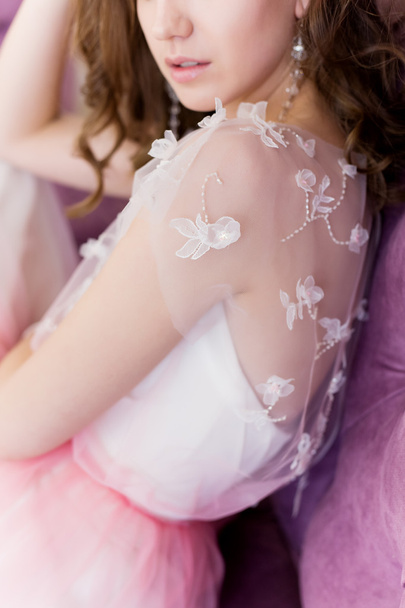 mooi sexy schattige zachte meisje loopt in een lichte witte jurk op een bloeiende tuin van felle zomerdag - Foto, afbeelding
