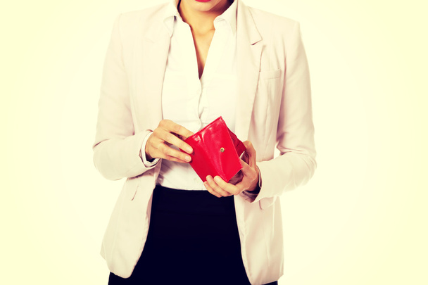 Worried business woman looking into her empty wallet - Foto, Bild