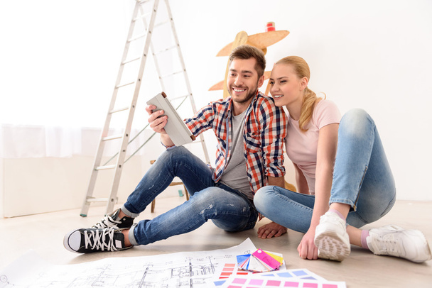 Cheerful couple looking at construction house plan - Foto, Imagen