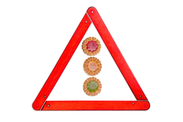 Μπισκότο με χρώμα φωτός κυκλοφορίας ζελατίνης ανάμεσα στο προειδοποιητικό τρίγωνο - Φωτογραφία, εικόνα