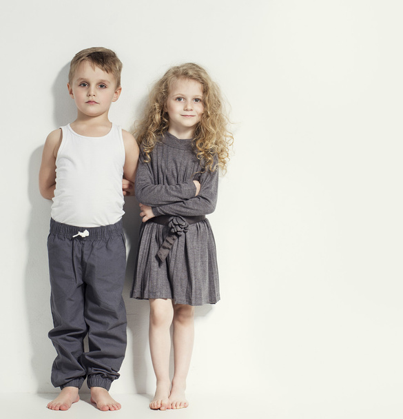 Funny lovely children. Fashionable little boy and girl in grey and white clothes and  barefoot. stylish kids in casual clothes with  different emotions. fashion children - Foto, Imagen