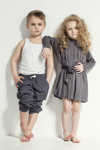 Funny lovely children. Fashionable little boy and girl in grey and white clothes and  barefoot. stylish kids in casual clothes with  different emotions. fashion children - Φωτογραφία, εικόνα