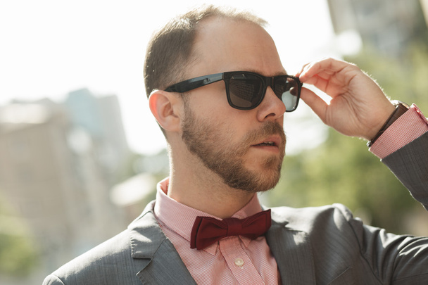 Sytlish businessman in sunglasses walking at city downtown - Фото, зображення