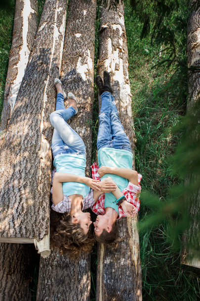 Couple lying on the felled logs - Фото, зображення