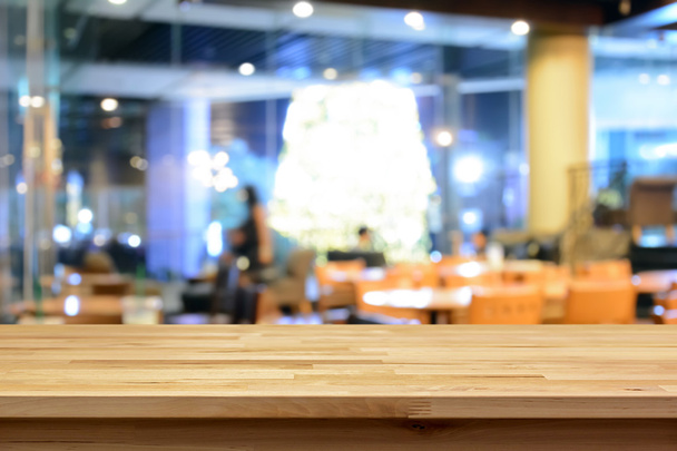 Tampo da mesa de madeira no fundo borrão do interior da cafetaria
  - Foto, Imagem