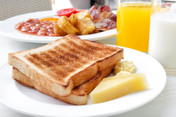 Pain grillé et beurre avec quelques boissons sur la table dans le petit déjeuner
 - Photo, image