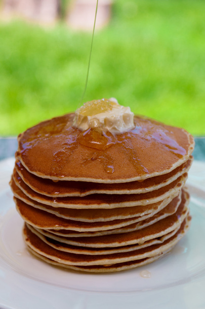 Pancakes with butter and honey on white plate - Fotó, kép