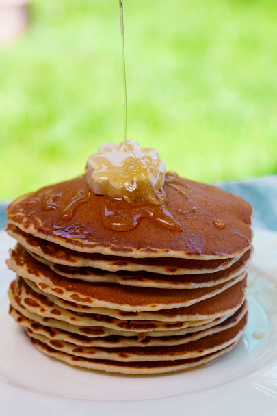 Блинчики с маслом и медом на белой тарелке
 - Фото, изображение