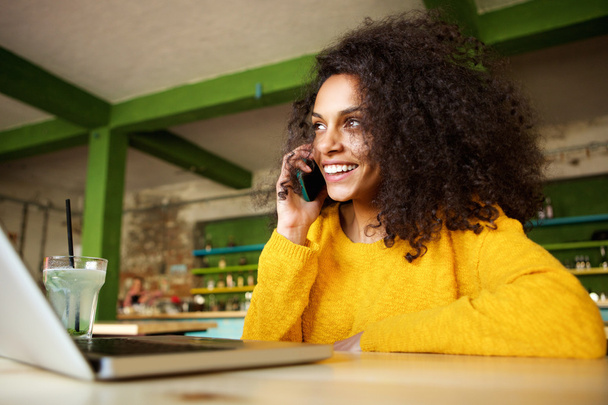 Ευτυχισμένος νεαρή γυναίκα στο café πραγματοποίηση τηλεφωνικής κλήσης  - Φωτογραφία, εικόνα