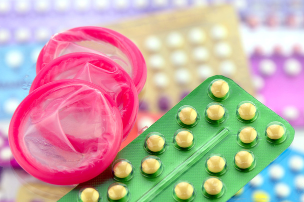 Condoom en mondelinge Contraceptieve Pil op apotheek toonbank. - Foto, afbeelding