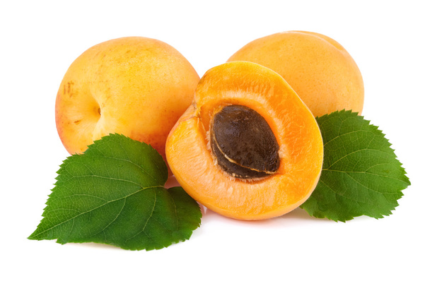 Meruňky closeup. Čerstvé meruňky a polovinu ovoce s jádra izolovaných na bílém - Fotografie, Obrázek