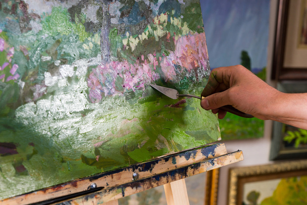 Close up view of painter's hand holding a palette knife - Foto, immagini