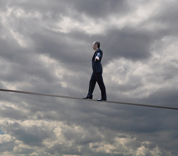 Üzletember egy kötélen egyensúlyoz - Fotó, kép