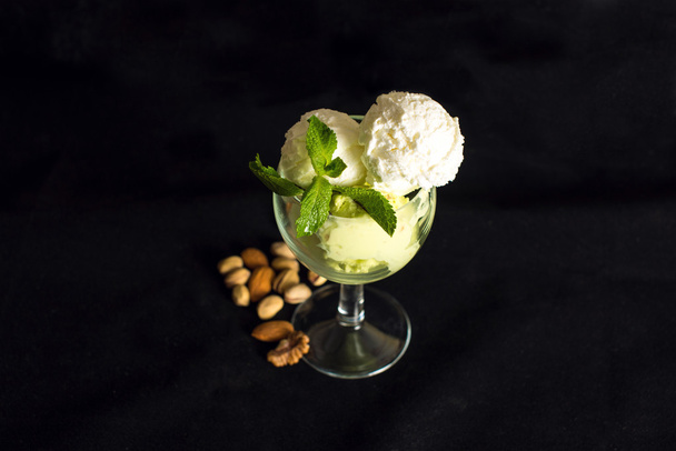 pistachio and vanilla ice cream with mint on black background - Zdjęcie, obraz