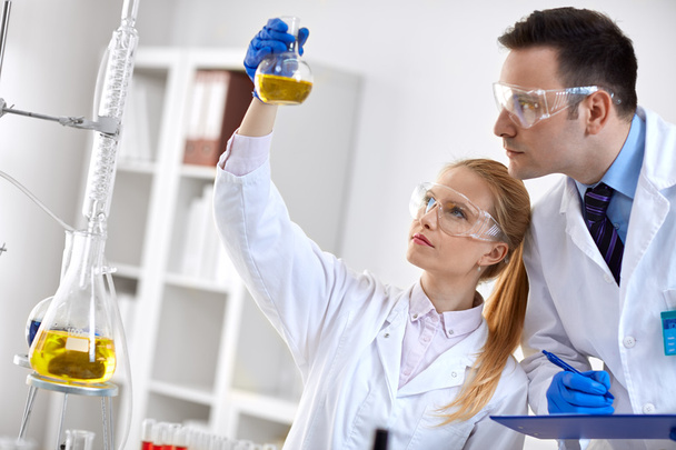 estudiante químico investigador sosteniendo matraz en laboratorio
 - Foto, Imagen