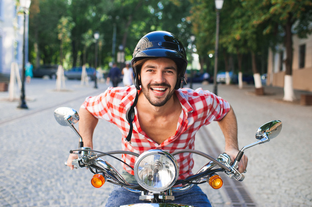 Handsome man riding a scooter  - Фото, зображення